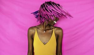 girl shaking her pink hair in front of a pink background